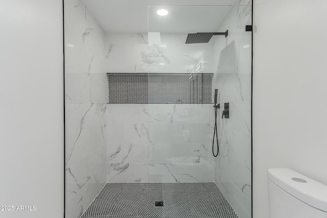 bathroom with toilet and tiled shower