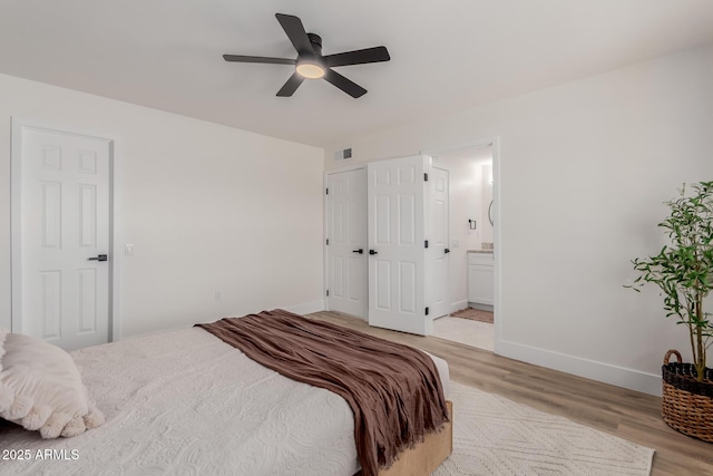 bedroom with connected bathroom, ceiling fan, and light wood-type flooring