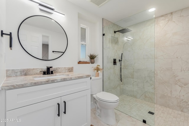 bathroom featuring vanity, toilet, and a tile shower