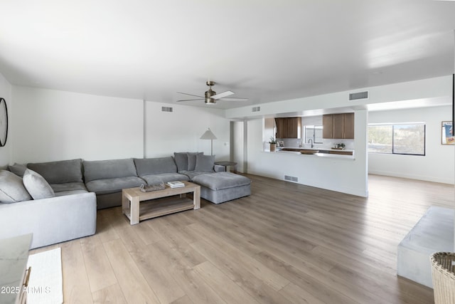 living room with light wood-type flooring and ceiling fan