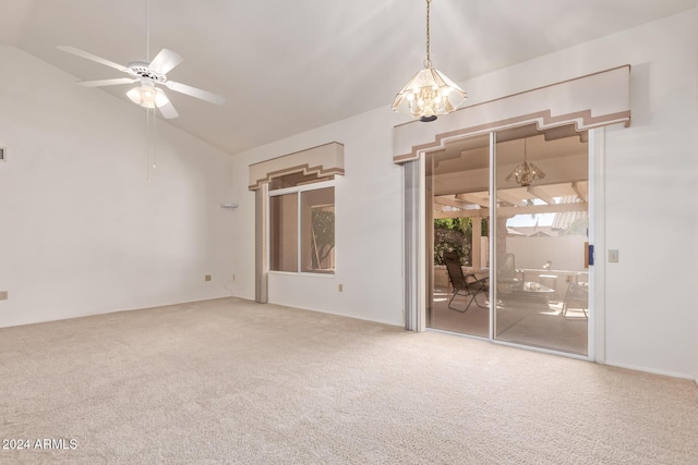 unfurnished room featuring ceiling fan with notable chandelier, carpet floors, and vaulted ceiling