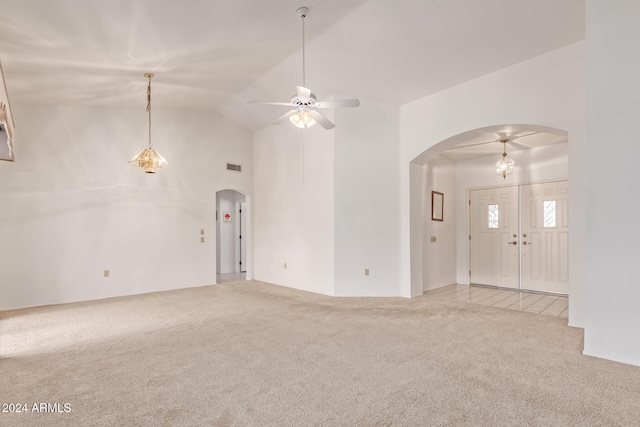 unfurnished living room featuring ceiling fan, light colored carpet, and lofted ceiling