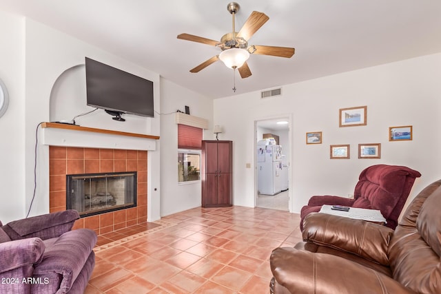 living room with tile patterned flooring, ceiling fan, and a tiled fireplace