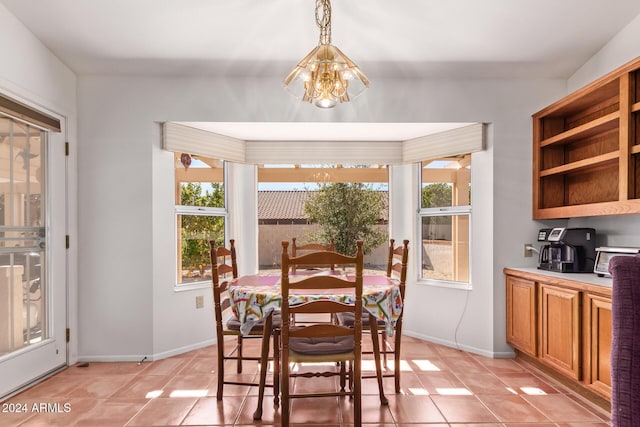 dining space with light tile patterned flooring and an inviting chandelier