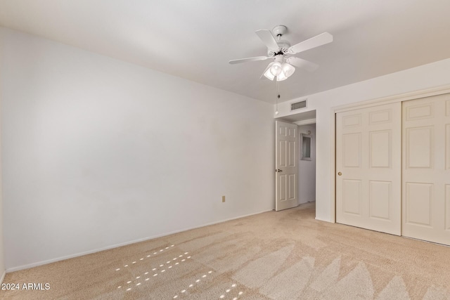 unfurnished bedroom featuring light carpet, a closet, and ceiling fan