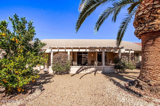 back of property with a pergola and a patio area