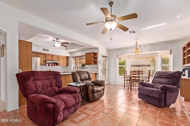 tiled living room featuring ceiling fan with notable chandelier, a tray ceiling, vaulted ceiling, and sink