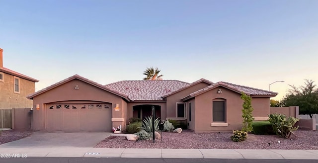 5339 W Kaler Cir, Glendale, AZ 85301 - mediterranean / spanish-style home with a tile roof, stucco siding, a garage, and concrete driveway