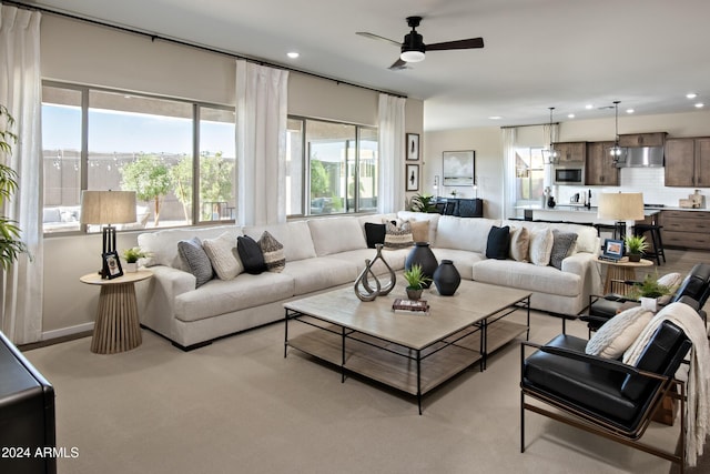 living room featuring ceiling fan and light colored carpet