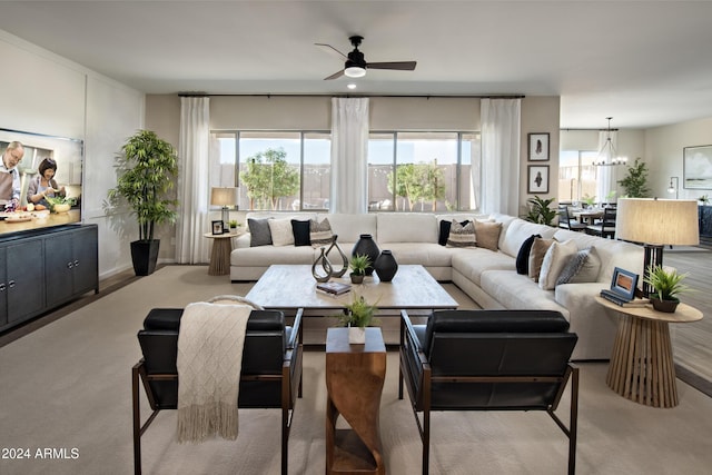 living room featuring ceiling fan with notable chandelier and light carpet