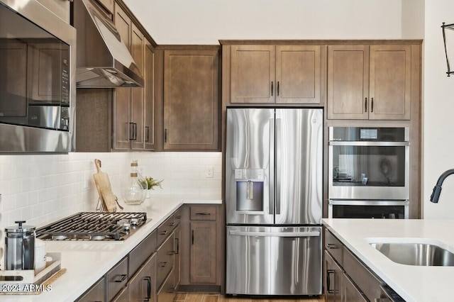 kitchen featuring decorative backsplash, sink, and appliances with stainless steel finishes