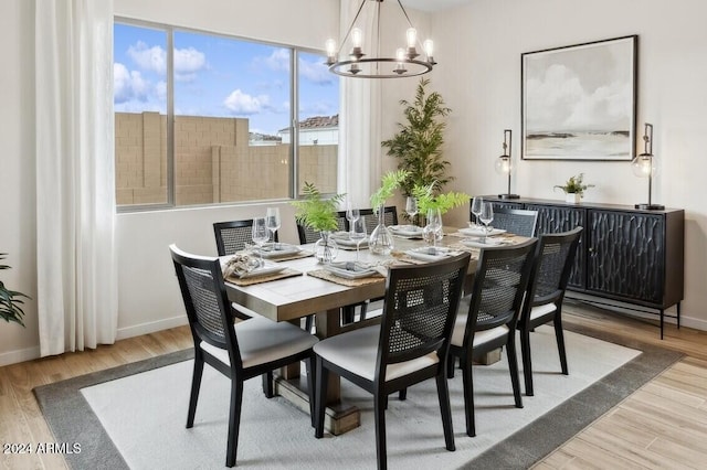 dining space featuring light hardwood / wood-style flooring and an inviting chandelier