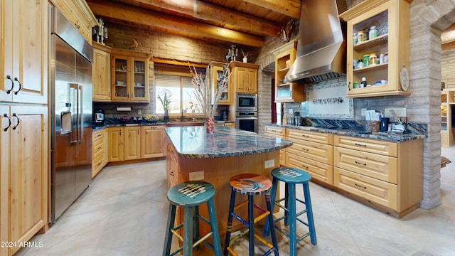 kitchen featuring backsplash, a center island, beamed ceiling, and wall chimney exhaust hood