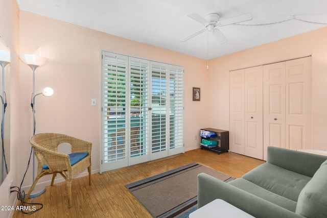 living room featuring wood-type flooring and ceiling fan