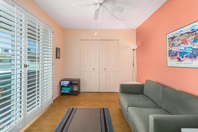 living room with wood-type flooring, a textured ceiling, and ceiling fan