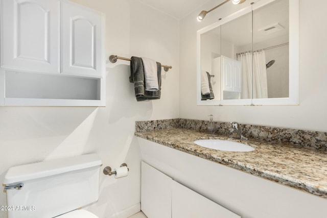 bathroom with vanity, curtained shower, and toilet