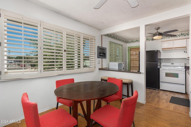 dining area with a textured ceiling, washer / clothes dryer, ceiling fan, and dark wood-type flooring