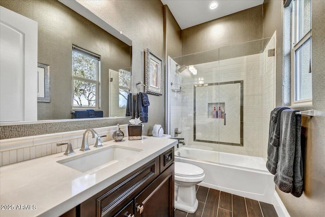 full bathroom with vanity, shower / bath combination with glass door, and toilet