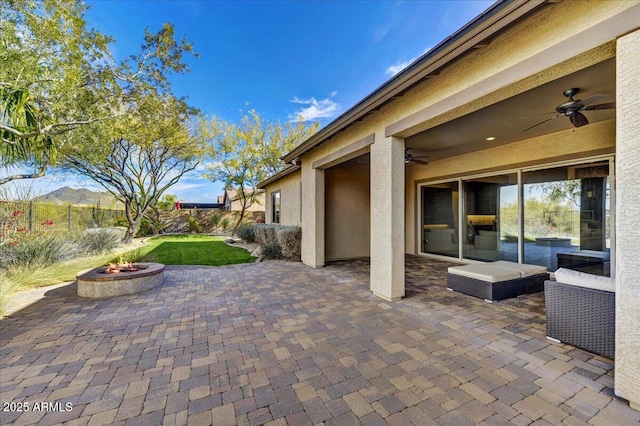 view of patio / terrace with a mountain view, a fire pit, and ceiling fan