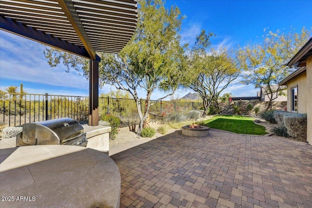 view of patio / terrace featuring a pergola, area for grilling, and a fire pit