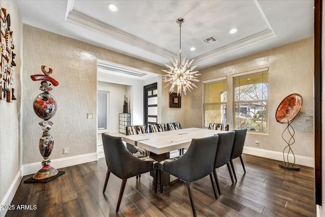 dining area featuring a tray ceiling, dark wood-type flooring, and ornamental molding