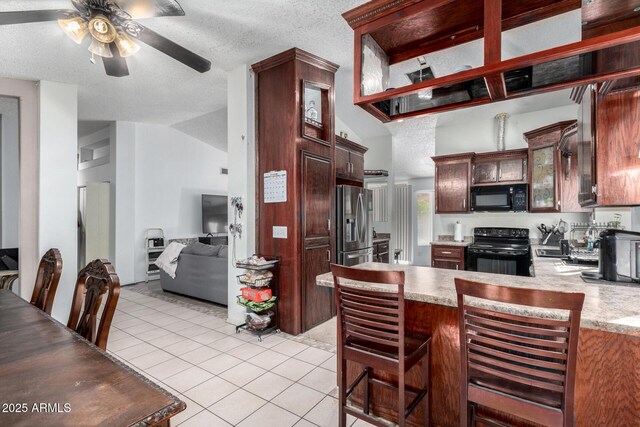 kitchen featuring vaulted ceiling, black appliances, kitchen peninsula, a textured ceiling, and light tile patterned floors