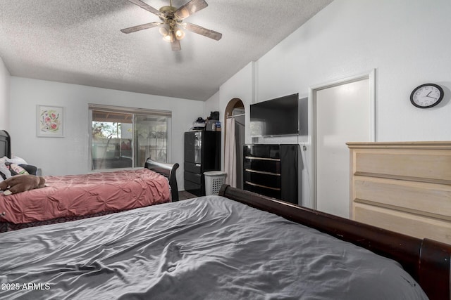 bedroom featuring a textured ceiling, lofted ceiling, black refrigerator, access to exterior, and ceiling fan