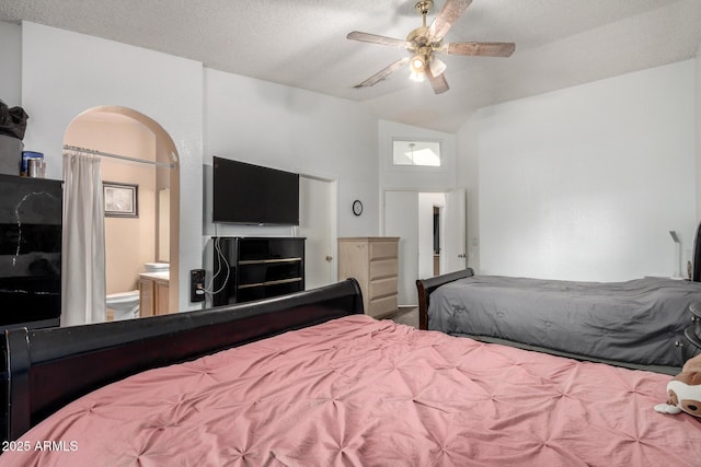 bedroom with ceiling fan, ensuite bath, a textured ceiling, and lofted ceiling