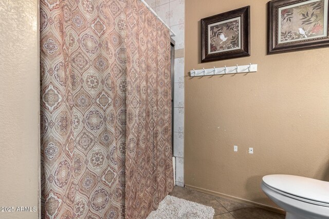 bathroom featuring toilet, a shower with curtain, and tile patterned flooring