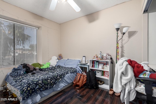 bedroom with a textured ceiling, ceiling fan, and dark hardwood / wood-style flooring