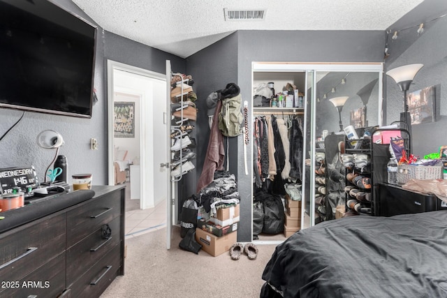 carpeted bedroom featuring a textured ceiling and a closet