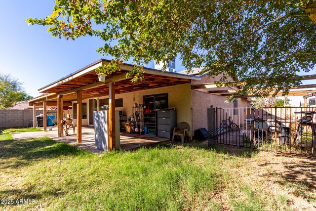 rear view of property featuring a patio area and a yard