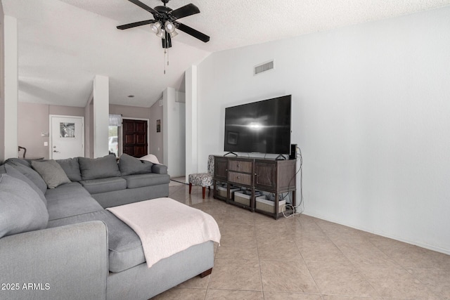 living room with a textured ceiling, ceiling fan, light tile patterned floors, and lofted ceiling