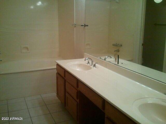 bathroom featuring tile patterned flooring, vanity, and a bathtub