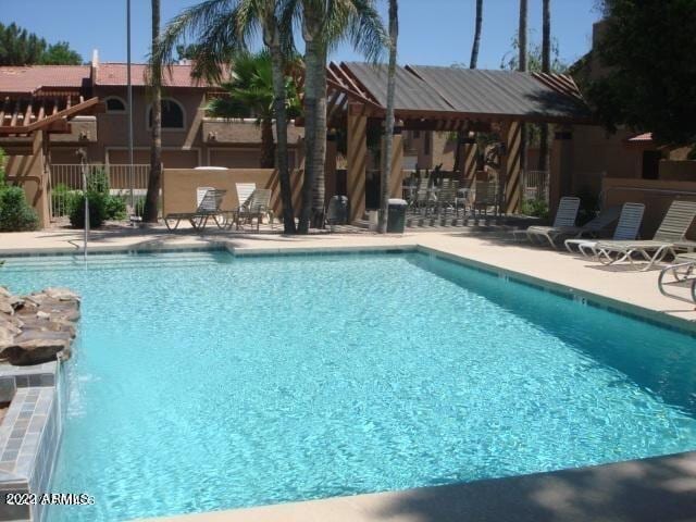 view of swimming pool with pool water feature and a gazebo