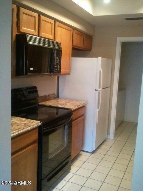 kitchen with light tile patterned floors and black appliances