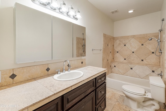 full bathroom with tiled shower / bath combo, vanity, and toilet