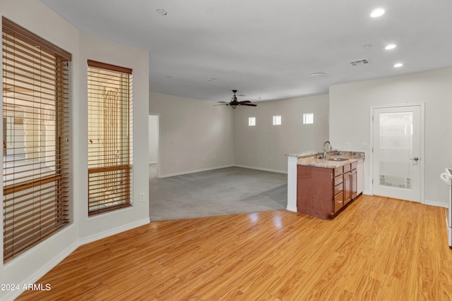 unfurnished room with sink, ceiling fan, and light hardwood / wood-style flooring