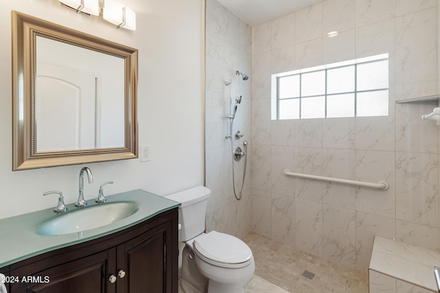 bathroom featuring vanity, tiled shower, and toilet