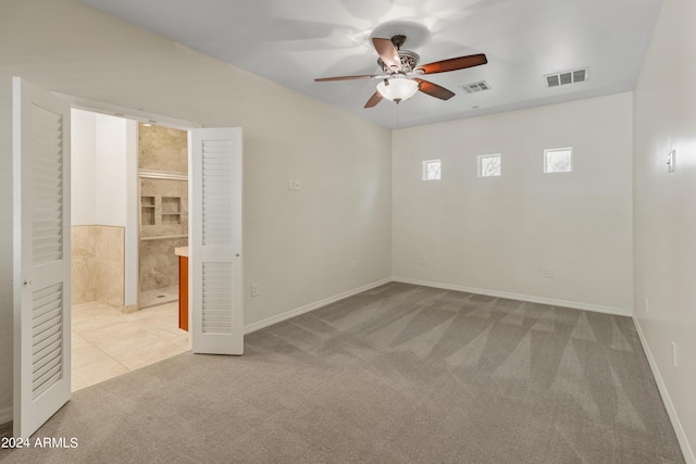 unfurnished room featuring light carpet and ceiling fan