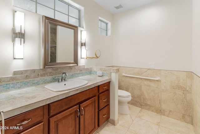 bathroom featuring tile walls, vanity, and toilet