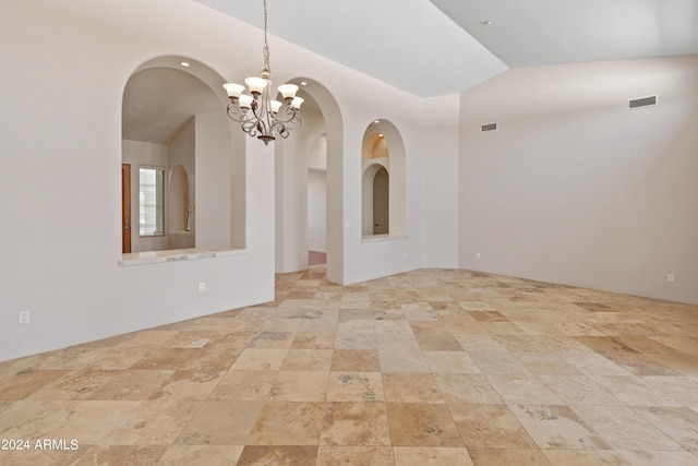 unfurnished room with lofted ceiling and a notable chandelier