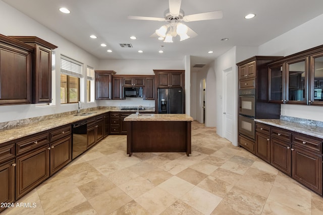 kitchen with a center island with sink, dark brown cabinets, black appliances, ceiling fan, and sink