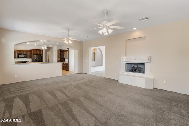 unfurnished living room featuring light carpet and ceiling fan