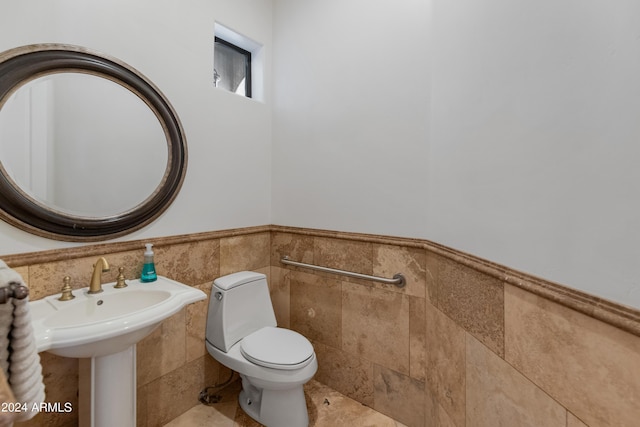 bathroom with tile walls and toilet