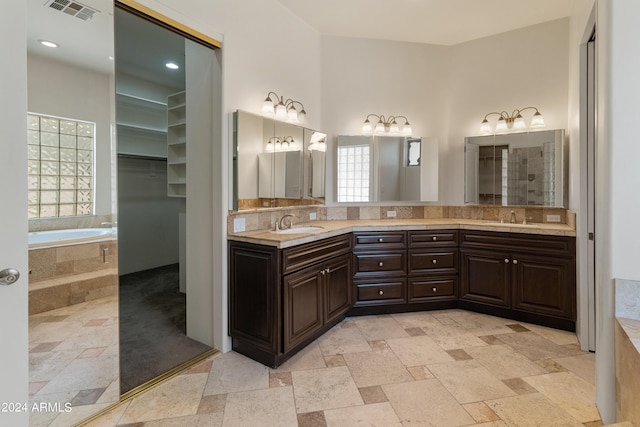 bathroom featuring vanity and tiled bath