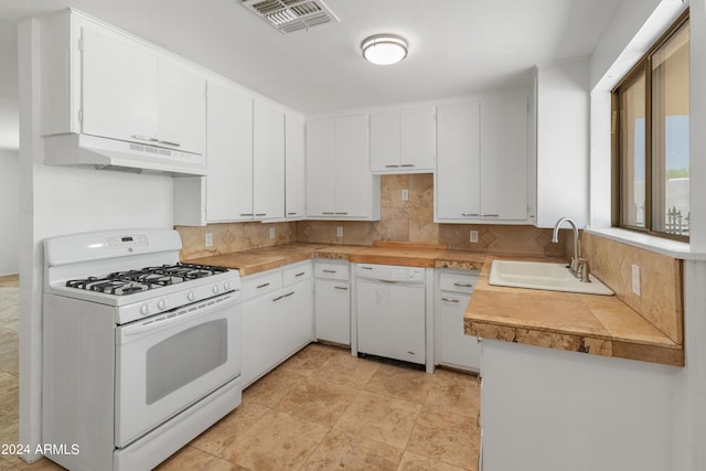 kitchen featuring sink, white appliances, white cabinets, and backsplash