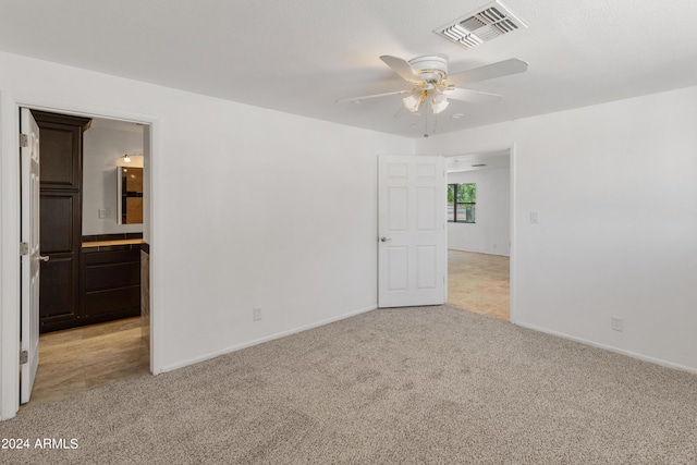 unfurnished room featuring light carpet and ceiling fan