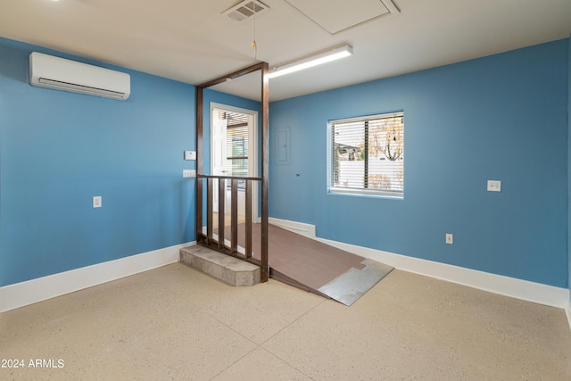 unfurnished room with an AC wall unit