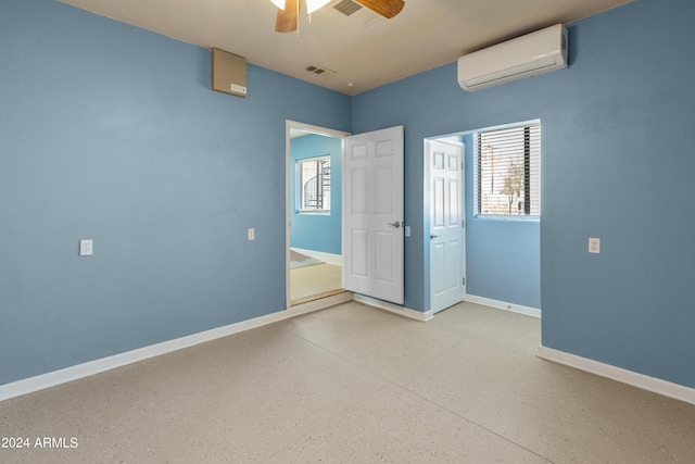 unfurnished bedroom with an AC wall unit and ceiling fan